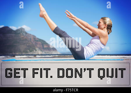 Composite image of blonde fit faire du yoga sur la plage Banque D'Images