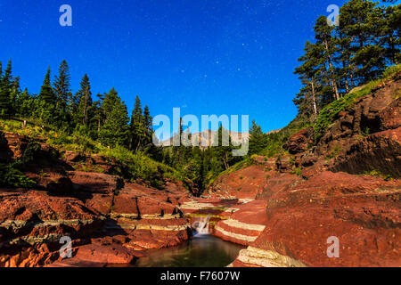 Cassiopée et les northern stars sur le Red Rock Canyon dans le parc national des Lacs-Waterton, en Alberta, à l'allumage d'une cire Banque D'Images