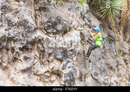 Banos, Equateur - 30 novembre 2014 : Défi de basalte de Tungurahua, Adolescent Amérique Girl Climbing une paroi verticale Banque D'Images