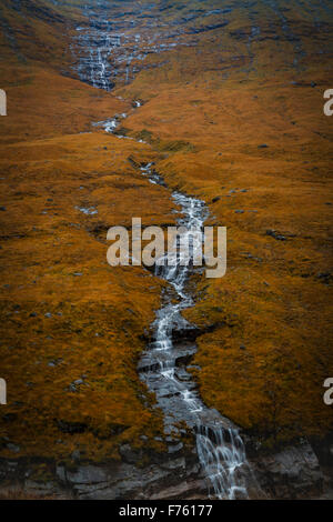 Cascade de long au-dessus des collines couvertes de granit sur bracken, automne Ecosse Banque D'Images