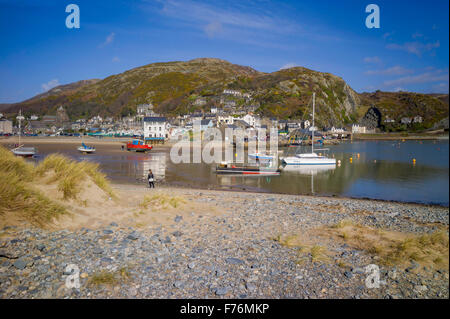 Une vue sur la plage de galets vers Barmouth ville et le port avec de petites maisons éparpillées sur les collines environnantes. Banque D'Images