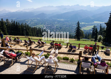 Les gens profiter du soleil au soleil dans des chaises longues sur la montagne Gubałówka, Zakopane, comté de Tatra, Pologne, Europe Banque D'Images
