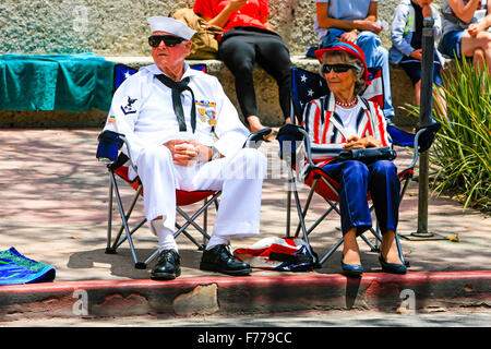 WW2 vétéran de la marine américaine avec sa femme s'asseoir sur le trottoir et regarder le défilé du 4 juillet à Santa Barbara en Californie Banque D'Images