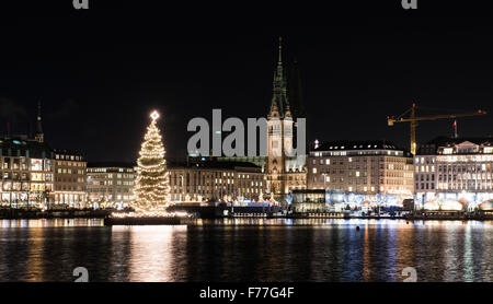 Hambourg, Allemagne. 26 Nov, 2015. Un sapin Noël sur le lac Inner Alster à Hambourg, Allemagne, 26 novembre 2015. L'hôtel de ville peut être vu dans l'arrière-plan. PHOTO : DANIEL BOCKWOLDT/DPA/Alamy Live News Banque D'Images