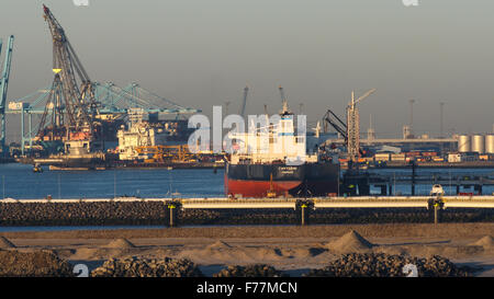 Mer du Nord, à bord des navires arrivant au port de Rotterdam au lever du soleil avec l'expédition, les conteneurs de vrac grues remorqueurs quayside Banque D'Images