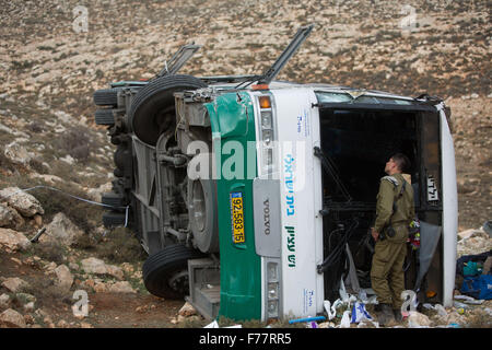 Jérusalem, Ramallah en Cisjordanie. 26 Nov, 2015. Un soldat israélien inspecte un bus s'est écrasé sur les lieux près de la colonie juive Hashachar Kohav, au nord-est de Ramallah en Cisjordanie, le 26 novembre 2015. Un soldat israélien a été tué et des dizaines de blessés dans un accident d'autobus mortel en Cisjordanie le Jeudi, les autorités israéliennes ont dit. L'autobus, circulant près de la colonie juive Hashachar Kohav, au nord-est de Ramallah en Cisjordanie, a été transportant des soldats lorsqu'il a renversé, la police israélienne et l'armée a dit dans des déclarations séparées. Source : Xinhua/JINI/Alamy Live News Banque D'Images