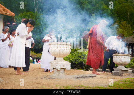 Sri Lanka, Kandy - monk s'allumer de l'encens dans le Temple de la dent, le Sri Dalada Maligawa, Site du patrimoine mondial de l'UNESCO Banque D'Images