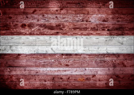 Une vignetted image de fond du drapeau de la Lettonie peints sur des planches de bois d'un mur ou le plancher. Banque D'Images