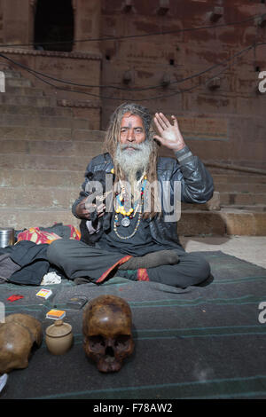 Bum bum noire Baba, un Sadhu saint siège avec son chiot et du crâne le long du Gange à Varanasi. Banque D'Images