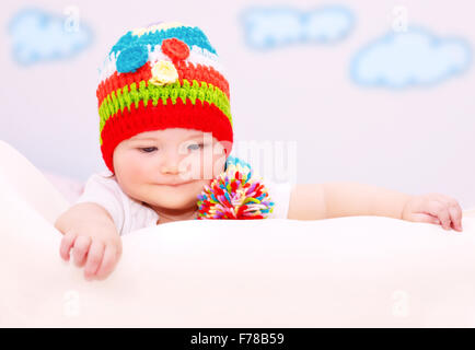 Portrait of cute little baby wearing colorful chapeau chaud confortable de détente dans la chambre des enfants, le mode de vie sain, heureux enfant insouciante Banque D'Images