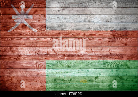 Une vignetted background image du drapeau d'Oman sur les planches de bois d'un mur ou le plancher. Banque D'Images