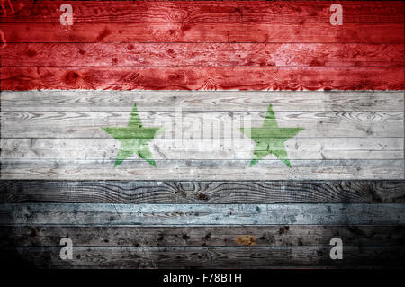 Une vignetted image de fond du drapeau de la Syrie sur les planches de bois d'un mur ou le plancher. Banque D'Images
