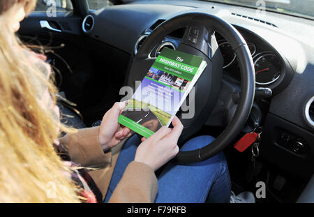 Jeune pilote féminin avec l'édition 2015 du Highway Code UK - posé par modèle Banque D'Images