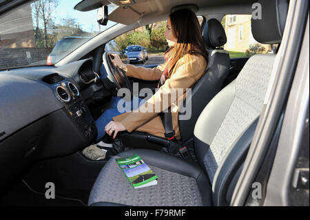 Jeune pilote féminin avec l'édition 2015 du Highway Code UK - posé par modèle Banque D'Images