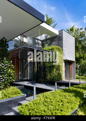 Entrée privée sur une passerelle avec piscines avec carpes koï dans une maison à Cove Way, Sentosa, Singapour conçu par Robert Greg Shand Architectes Banque D'Images