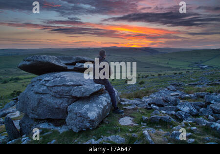 Photographe sur Bodmin Moor en regardant le soleil se couche sur le paysage Banque D'Images