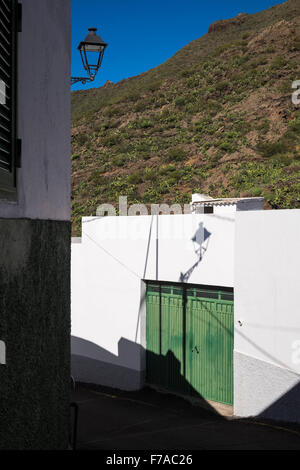 Ombre de streetlight sur un mur blanc et vert metal porte de garage dans le village d'El Molledo, tenerife, Îles Canaries Banque D'Images