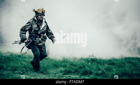 Soldat sur le champ de bataille en camouflage vu à travers la brume et la fumée. Banque D'Images