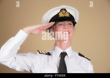 Officier de la marine en uniforme féminin d'un commandant lt portant un chapeau et saluant Banque D'Images
