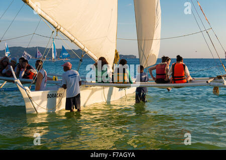 BORACAY, PHILIPPINES - 17 MAI 2015 : pas de touristes en route pour une croisière au coucher du soleil sur un bateau philippin traditionnel. Banque D'Images