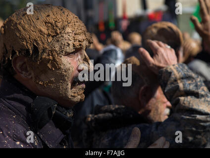 L'homme musulman chiite iranien couvert de boue pendant la journée, Ashura, province du Kurdistan, l'Iran Bijar Banque D'Images