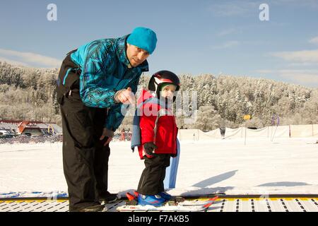 Skieur peu avec son père pour la première fois sur des skis. Banque D'Images