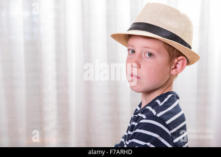 Jeune garçon avec chapeau à la colère dans l'appareil photo Banque D'Images