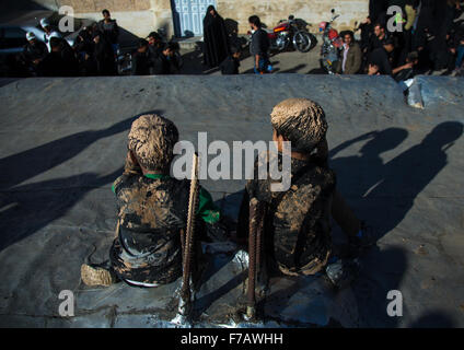 Les garçons musulmans chiites iraniens couvert de boue, le chant et l'auto-flagellating Au cours de la journée, Ashura, province du Kurdistan, l'Iran Bijar Banque D'Images