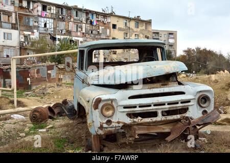 Abandonnés par la rouille van à Bakou, capitale de l'Azerbaïdjan, en face de mauvaise qualité bloc appartement Baku, Azerbaïdjan - 14 NOV 2013 Banque D'Images