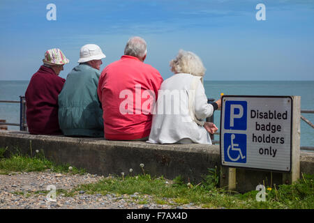 Groupe de retraités bénéficiant sur la mer au soleil à St Margarets Bay près de Dover Kent Banque D'Images