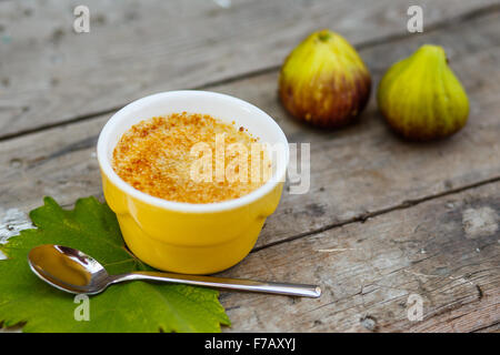L'alimentation saine : Delicious french dessert crème brûlée, crème brûlée, crème catalane, Trinity en crème Bol en porcelaine jaune sur bois L'alimentation saine : Delicious french dessert crème brûlée, crème brûlée, crème catalane, Trinity en crème Bol en porcelaine jaune sur bois