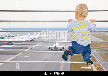 Little baby boy en attente d'embarquement à l'aéroport en vol et l'hôtel de transit à avion à près de porte de départ Banque D'Images