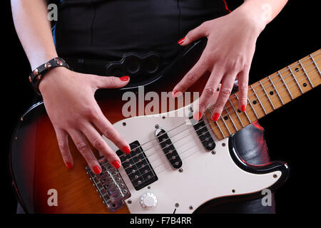 Sur la main de femme détail d'une guitare dans le noir en arrière. Rock Star Banque D'Images