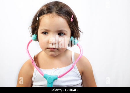 Cute little girl Playing with toy médecin stéthoscope. Plus isolé sur fond blanc Banque D'Images