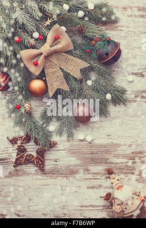 Belle décoration de Noël avec la neige sapin. La pointe d'une branche d'arbre et décoration de Noël sur un fond de bois rustique Banque D'Images