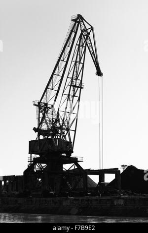 Silhouette sombre de grue du port industriel. La Bulgarie, la côte du Danube. Noir et blanc photo verticale Banque D'Images