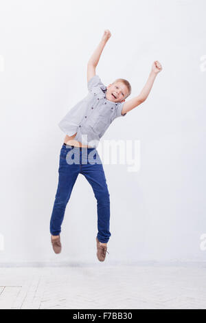 Happy Young boy jumping on white background Banque D'Images