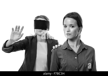 Deux secteurs d'une femme les yeux bandés et l'autre aidant Banque D'Images