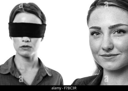 Deux secteurs d'une femme les yeux bandés et l'autre aidant Banque D'Images