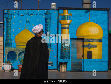 Le mollah en passant en face d'une peinture représentant une mosquée, comté Central, Qom, Iran Banque D'Images