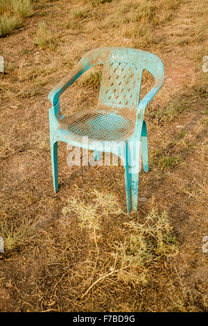 Retro grunge fauteuil vert plastique endommagés et abandonnés dans un champ Banque D'Images