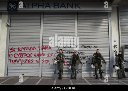 Athènes, Grèce. 28 Nov, 2015. La police anti-émeute guard une banque sur les manifestants qui ont pulvérisé les messages contre l'extradition possible aux autorités italiennes de cinq étudiants grecs qui ont participé à la manifestation anti-capitaliste AUCUNE Expo à Milan le 1er mai 2015. Beaucoup croient, c'est la première utilisation d'un mandat d'arrêt contre les manifestants et fait partie de la "guerre contre le terrorisme" permet d'accélérer l'extradition entre États de l'UE. Credit : Nikolas Georgiou/ZUMA/Alamy Fil Live News Banque D'Images