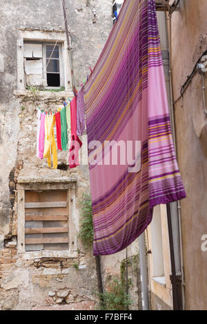 Une rue de la ville de Corfou avec lave-colorées en train de sécher dehors dans la rue. Corfu Banque D'Images