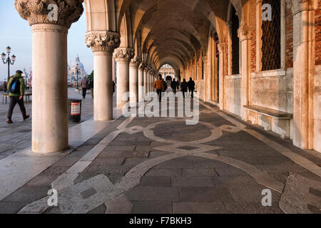 Venise, Italie Palazzo Ducale Arcade à colonnes, le Palais des Doges walkway tôt le matin avec des gens qui marchent Banque D'Images