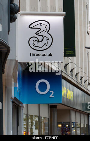 Trois & O2 réseau mobile logos de marques sur high street Banque D'Images