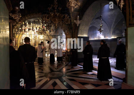 Des prêtres catholiques qui participent à une procession en face de l'autel de la crucifixion sur le côté gauche du Calvaire ou Golgotha traditionnellement considéré comme le site de la crucifixion de Jésus. L'autel principal appartient à l'Église orthodoxe grecque qui contient le rocher du Calvaire 12e Gare de la croix à l'intérieur de l'église du Saint-Sépulcre quartier chrétien de la vieille ville de Jérusalem Israël Banque D'Images