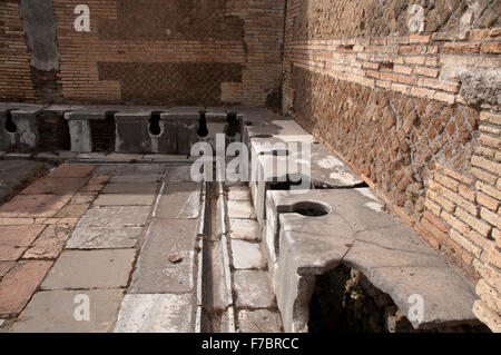 L'énorme fouilles de l'ancienne ville portuaire de l'ancienne Rome Ostia Antica montre des bâtiments bien conservés comme ça des toilettes. Banque D'Images