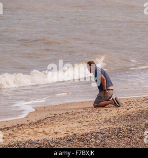 Un homme écrit dans le sable sur la plage, à Southwold, Suffolk , Angleterre , Angleterre , Royaume-Uni Banque D'Images