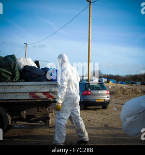 Calais, France. 28 Nov, 2015. Les travailleurs français vêtus de combinaisons blanches de protection de poursuivre l'opération de nettoyage au site migrants à Calais connu sous le nom de la jungle, les travailleurs enlevés supprimés tentes et d'ordures depuis le site et construit de nouveaux points de collecte des ordures. Credit : Duncan Penfold/Alamy Live News Banque D'Images