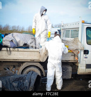 Calais, France. 28 Nov, 2015. Les travailleurs français vêtus de combinaisons blanches de protection de poursuivre l'opération de nettoyage au site migrants à Calais connu sous le nom de la jungle, les travailleurs enlevés supprimés tentes et d'ordures depuis le site et construit de nouveaux points de collecte des ordures. Credit : Duncan Penfold/Alamy Live News Banque D'Images